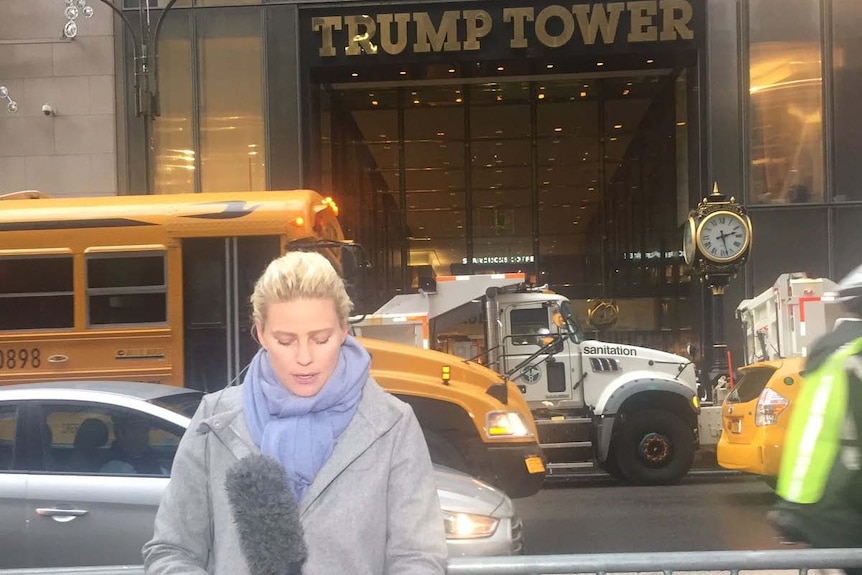 March standing outside Trump Tower holding microphone.