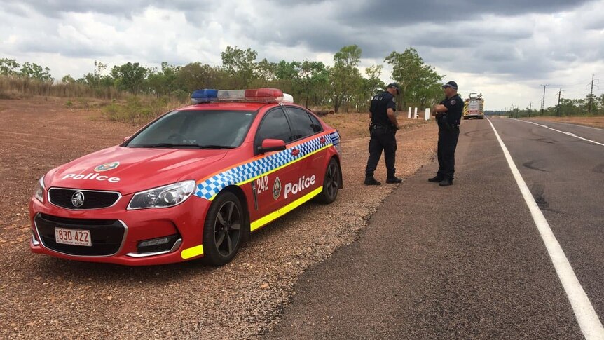 NT Police officers and car next to the side of a road