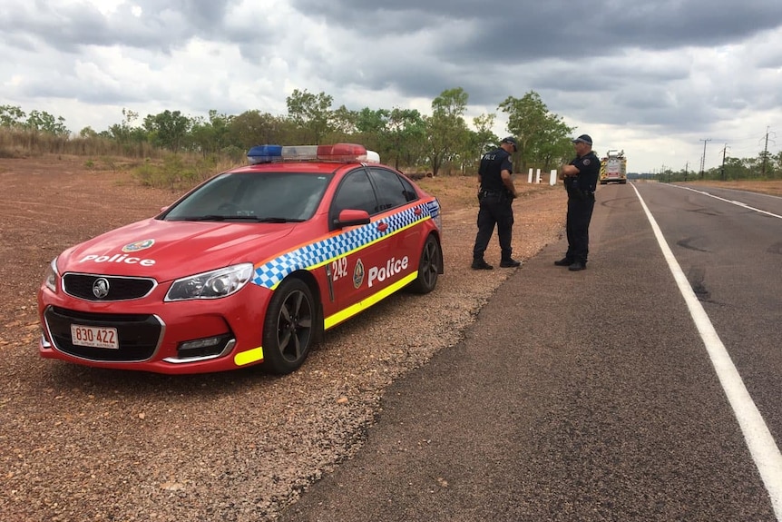 NT Police officers and car next to the side of a road