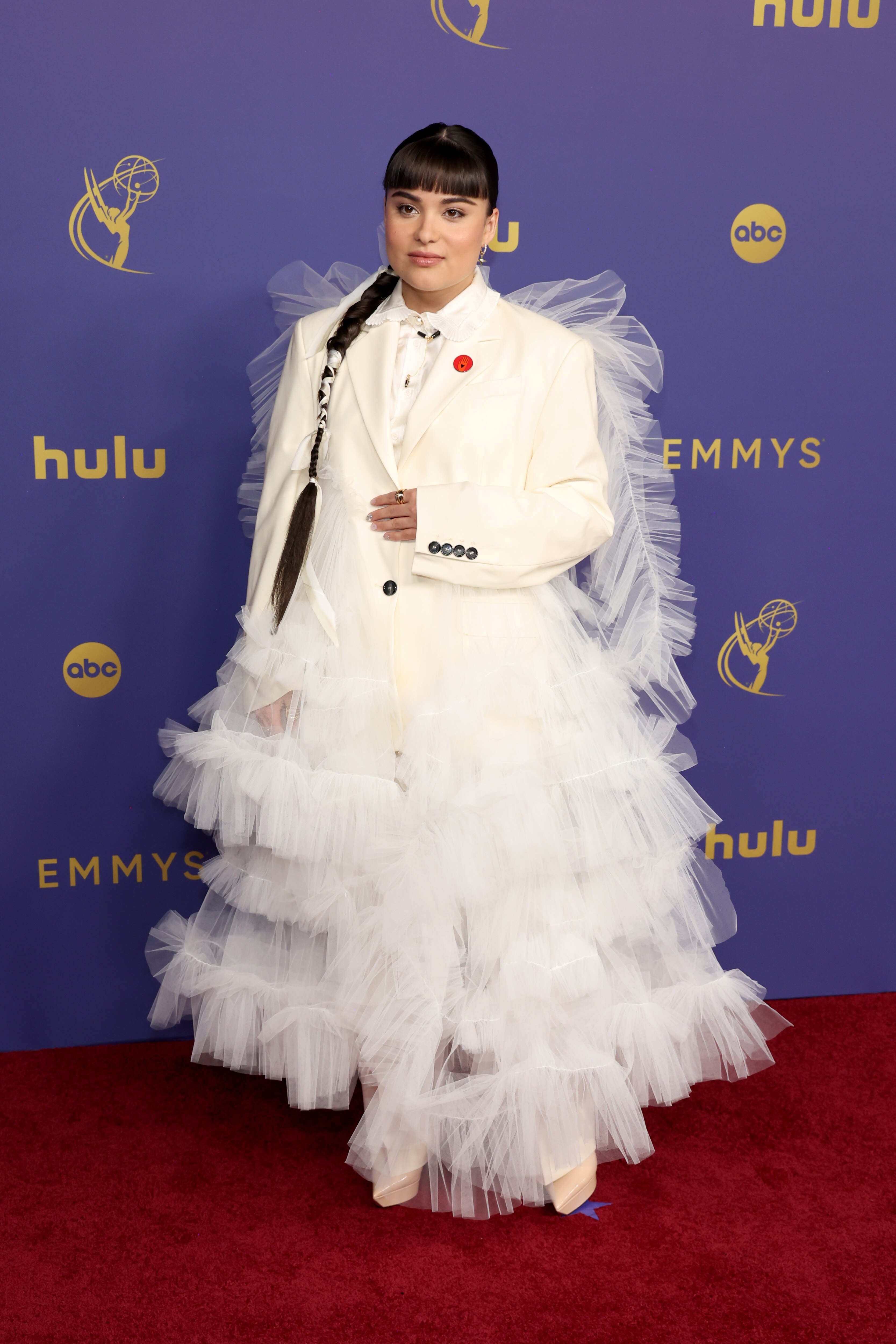 Devery Jacobs wearing a white suit with tulle ruffles