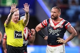 An NRL referee holds two hands up as he sends a Sydney Roosters player to the sin-bin.