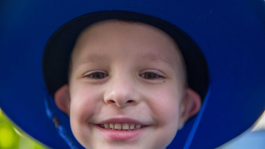 A boy smiles before he heads off to school.