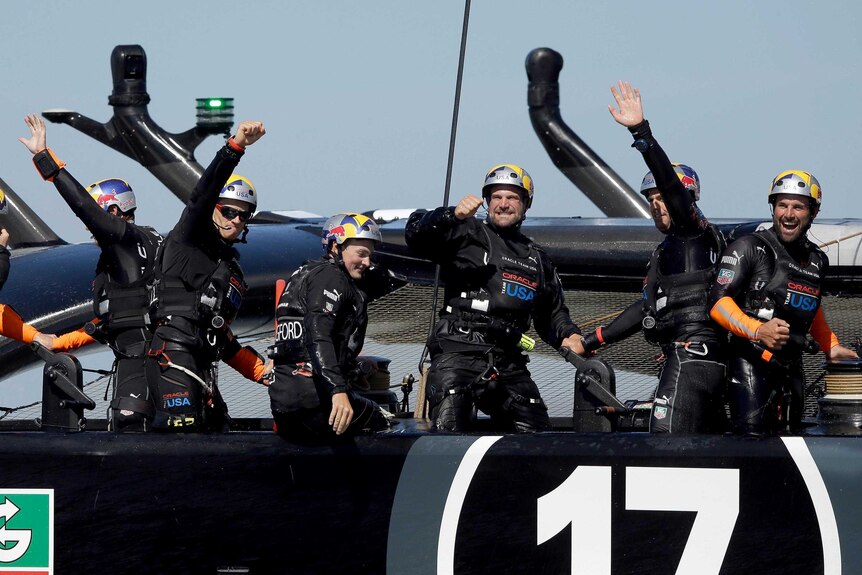 Oracle Team USA celebrates after they beat Emirates Team New Zealand in race 18.