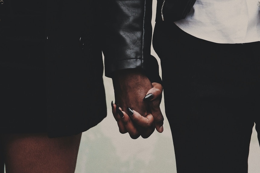 A young couple is holding hands