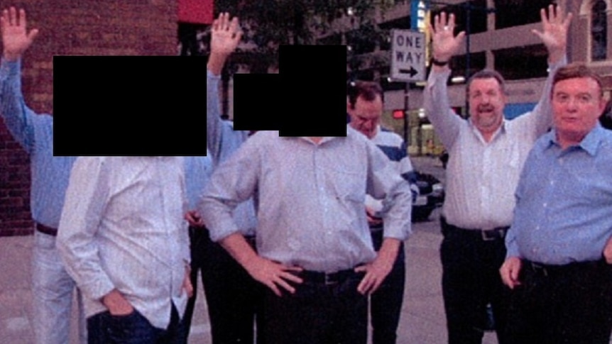 Paul Pisasale, Paul Tully and Carl Wulff stand on a street in the US with others.