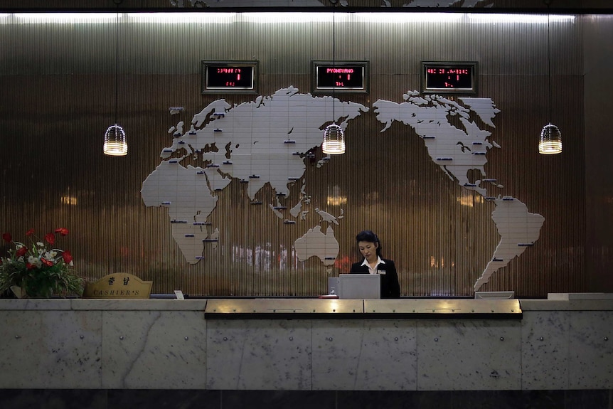 A hotel lobby with a Bondesque world map and clocks.