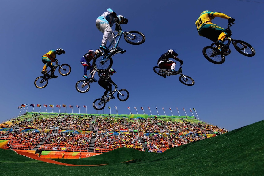 Six BMX competitors soar through the air in a jump during the Cycling BMX - Men's Quarter finals in Rio.