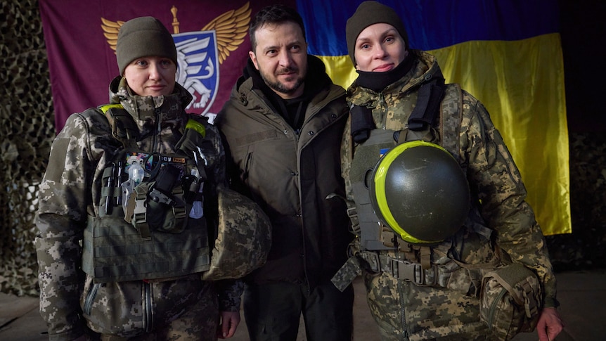 Ukrainian servicewomen pose for a photo with President Volodymyr Zelenskyy.