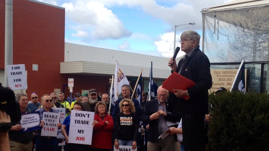 A group of union protestors in Devonport holding signs and flags