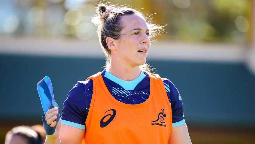 Rebecca Clough holds her right hand up at training.