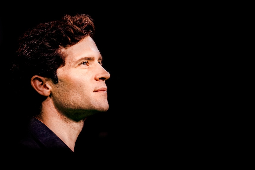 A side profile of astronomer Alan Duffy, looking across to the right through empty space.