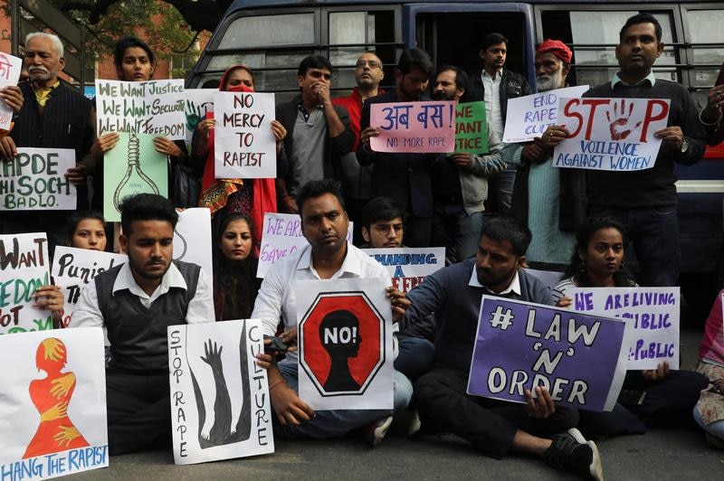 People hold placards and shout slogans as they take part in a protest.