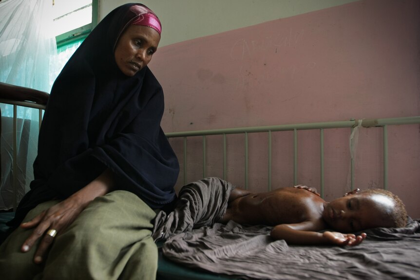 A Somalian mother looks at her malnourished and dehydrated child [AFP/AU-UN IST: Stuart Price]