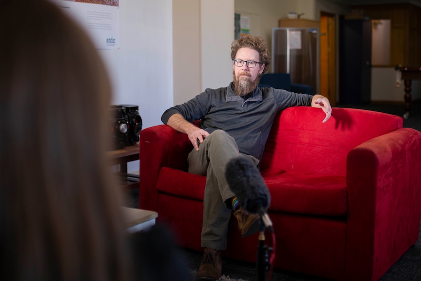 Damian Collins from Youth, Family, Community Connections sits on a couch.