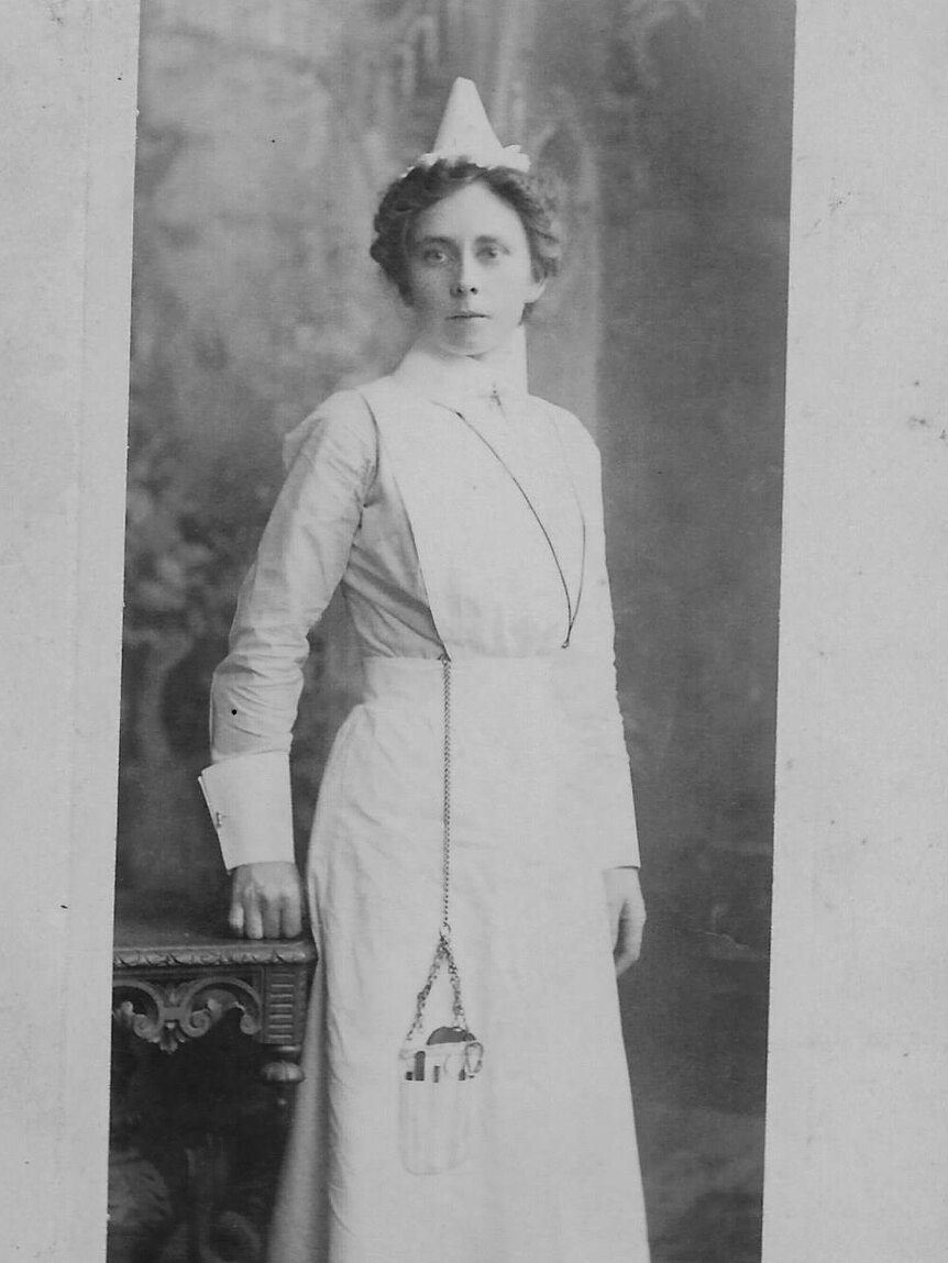 A black and white photo of a woman wearing a World War I nurse's uniform.