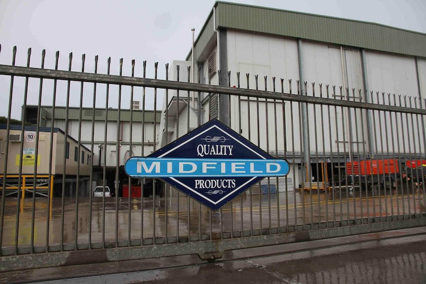 A factory with the fence and gates locked.