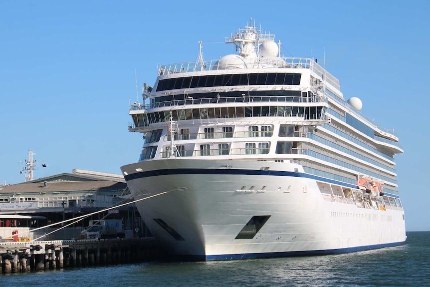 A cruise ship is docked in Melbourne on a clear, sunny day