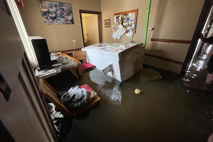 A fridge floats through a flooded home in Forbes