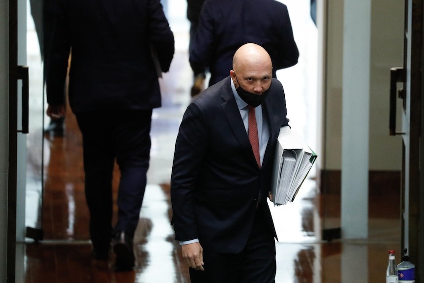 Peter Dutton bows, with a face mask under his nose, as he leaves the House of Representatives