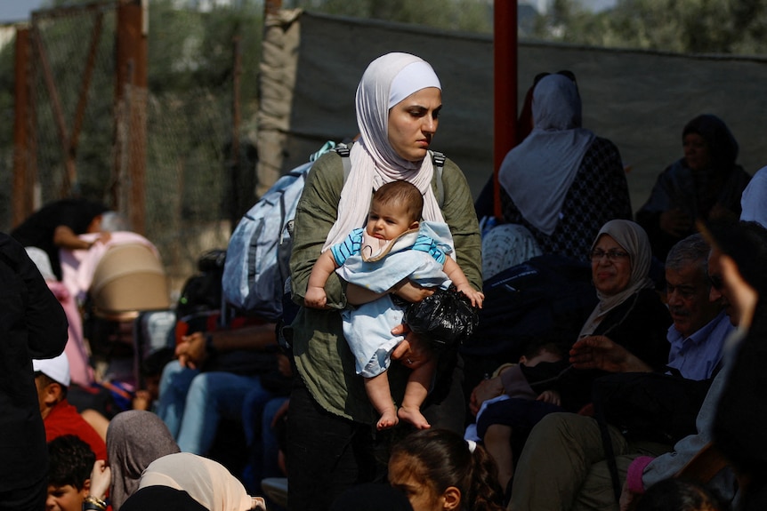 A woman holds a baby. 