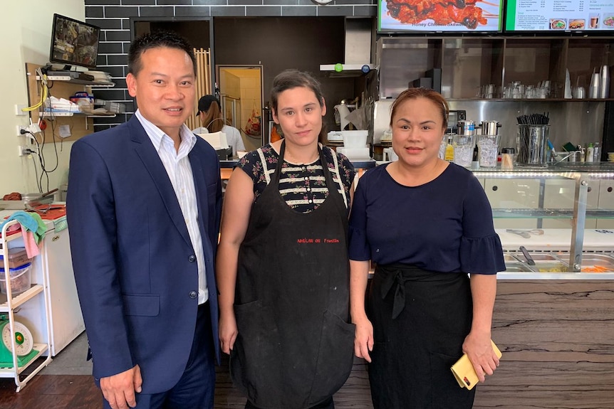 Three people standing at a snack bar counter