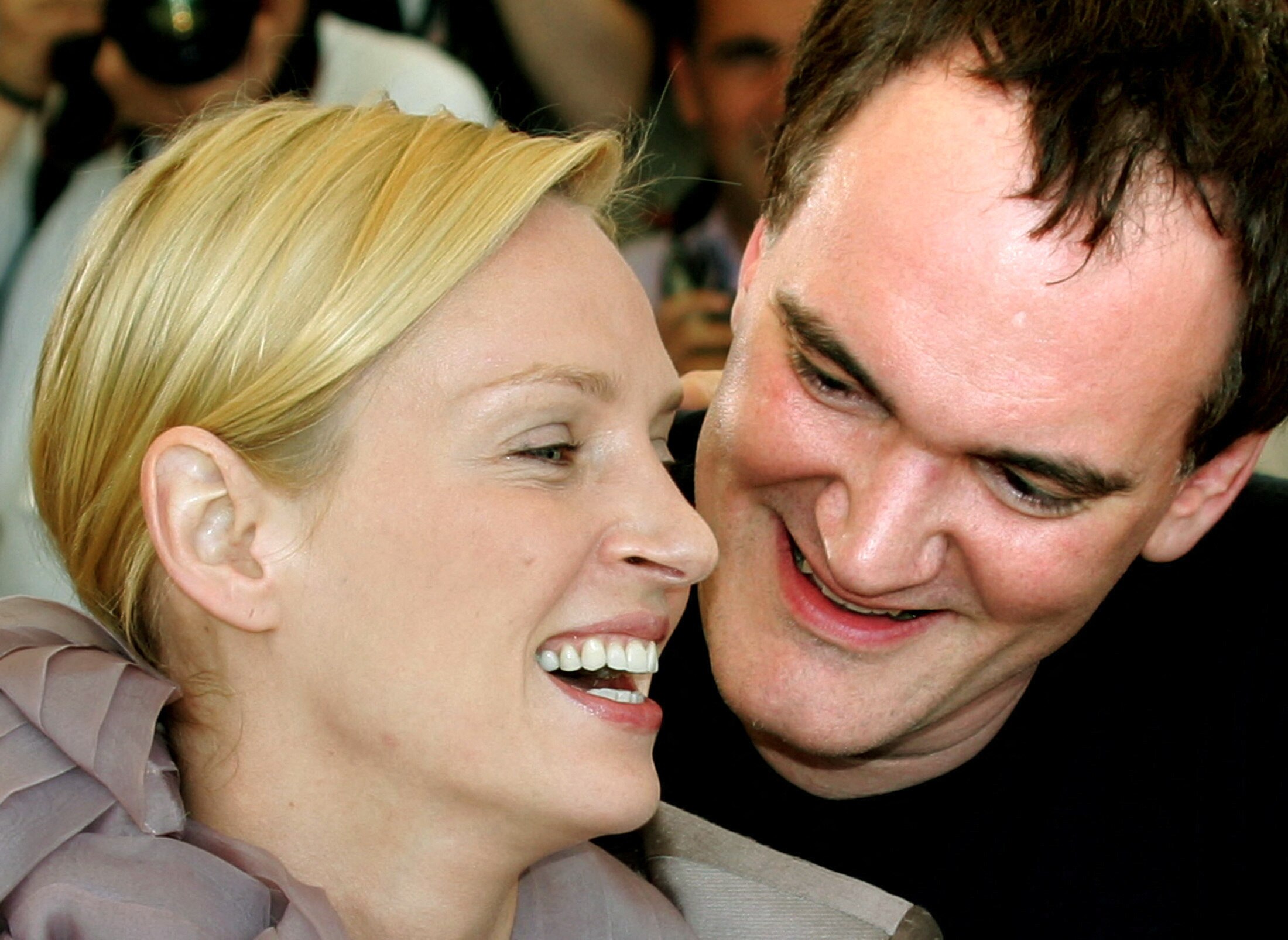 A blonde woman smiling next to a smiling man. 