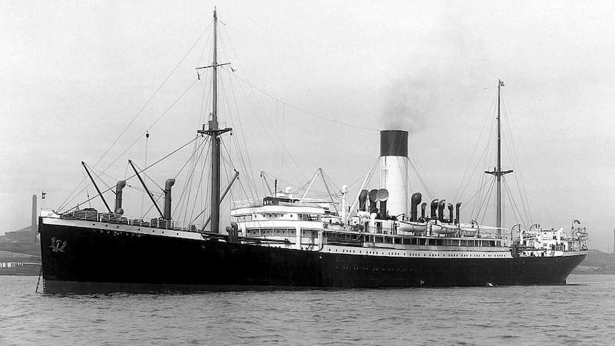 A black and white historical photo of a large ship with soldiers about