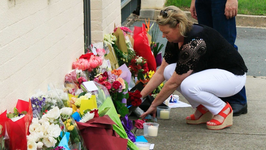 People leave flowers outside the French Embassy in Yarralumla.