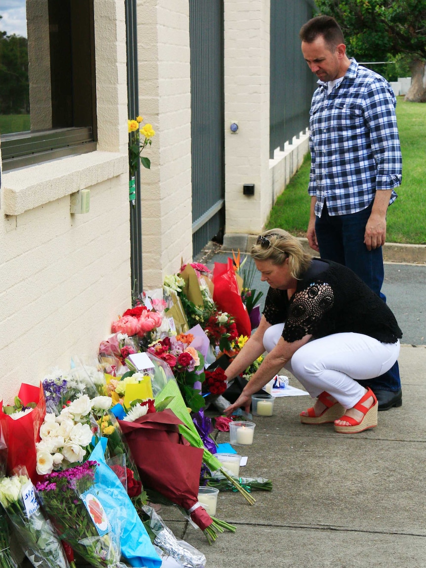 People leave flowers outside the French Embassy in Yarralumla.