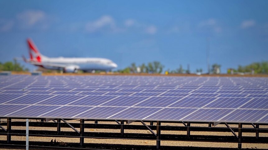 A Qantas plane beside solar panels