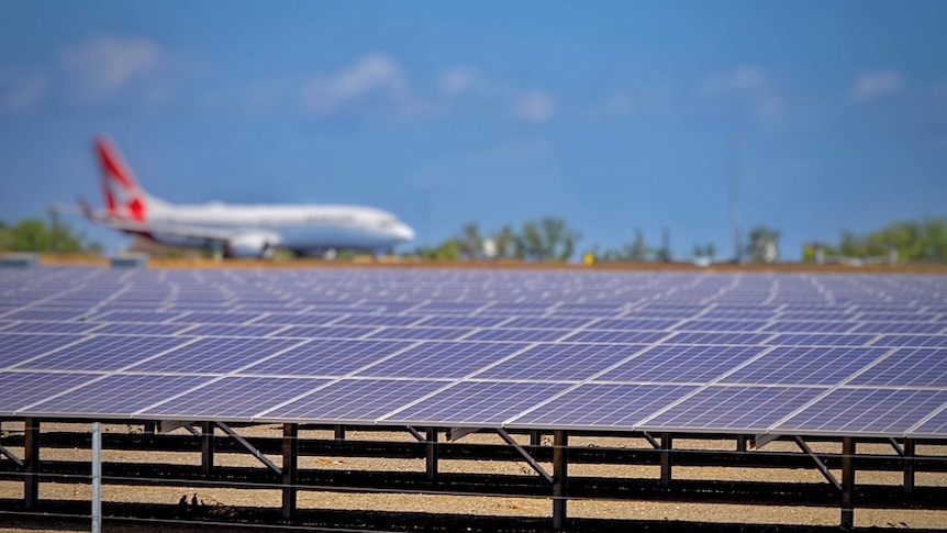 A Qantas plane beside solar panels