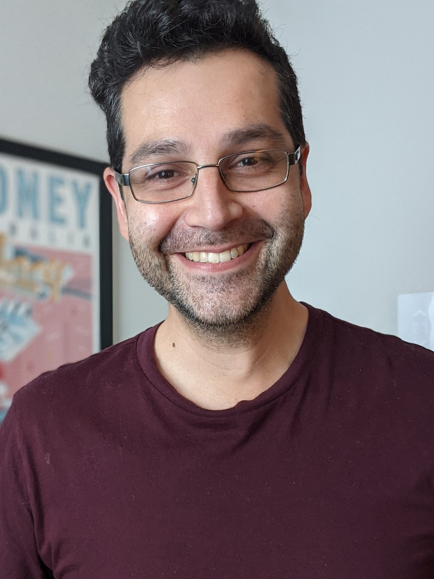 Daniel Pozo smiling. He has brown hair and reading glasses and some facial hair.