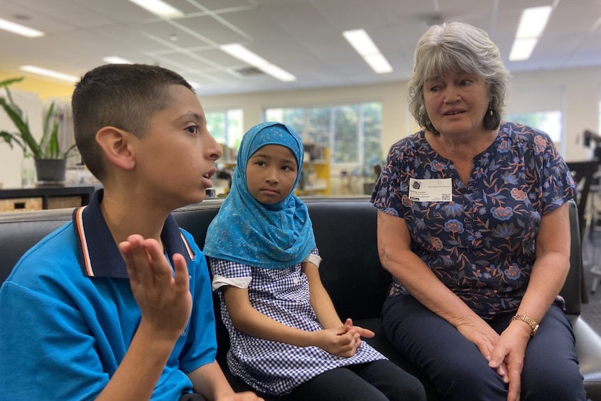 A grandmother speaks to two students.