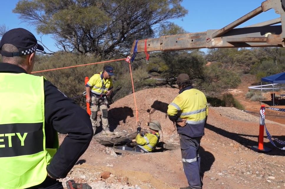 A man is lowered into a mine shaft