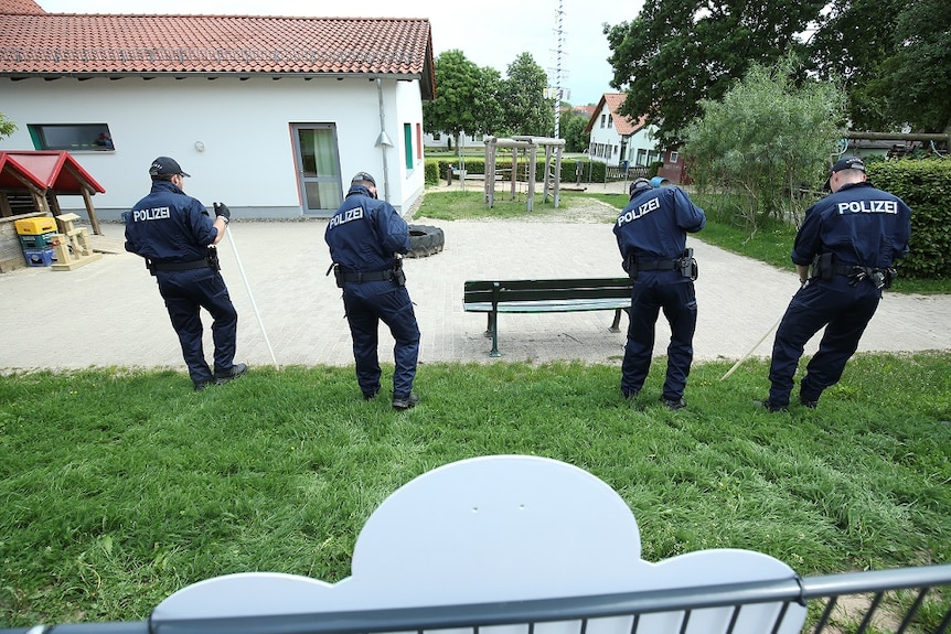 German police officers search neighbouring properties.