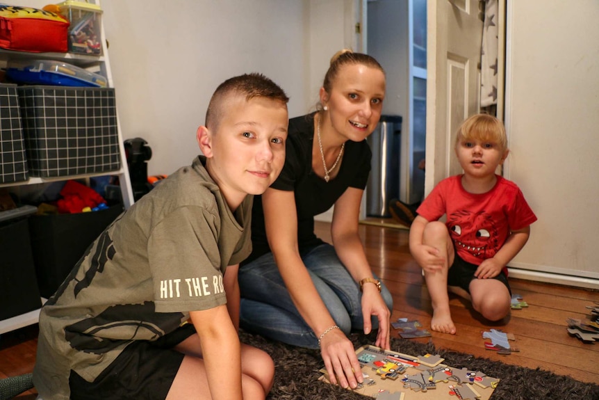 The young family play on the ground in their home.