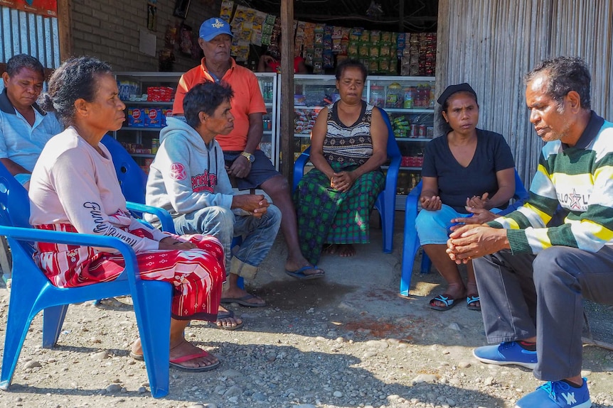 A group of East Timorese people sit in a circle talking