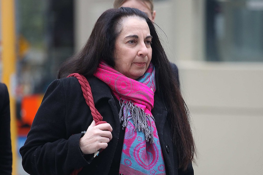 A mid-shot of Claremont prosecutor Carmel Barbagallo outside court wearing a black jacket and pink and blue scarf.