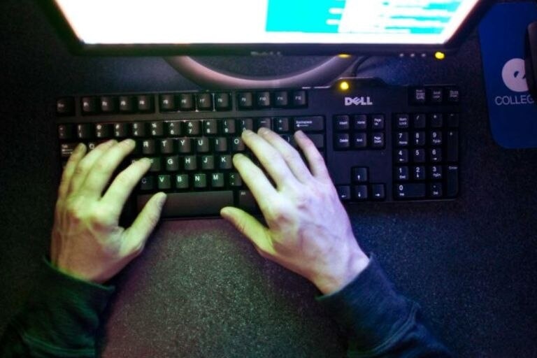 manos escribiendo en un teclado de computadora.