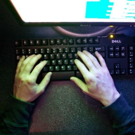 hands typing on a computer keyboard.