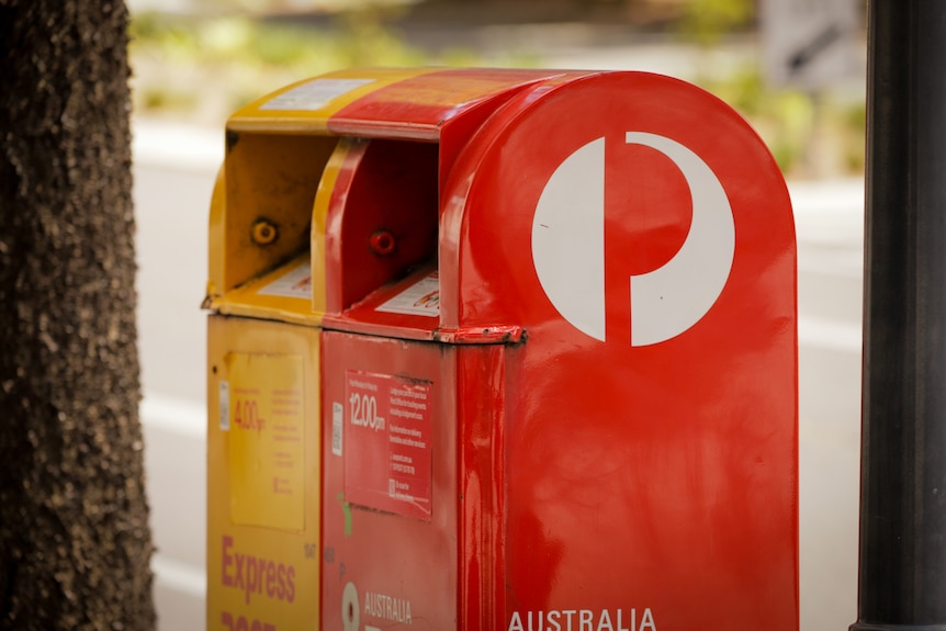A apir of mailboxes. One red, one yellow. 