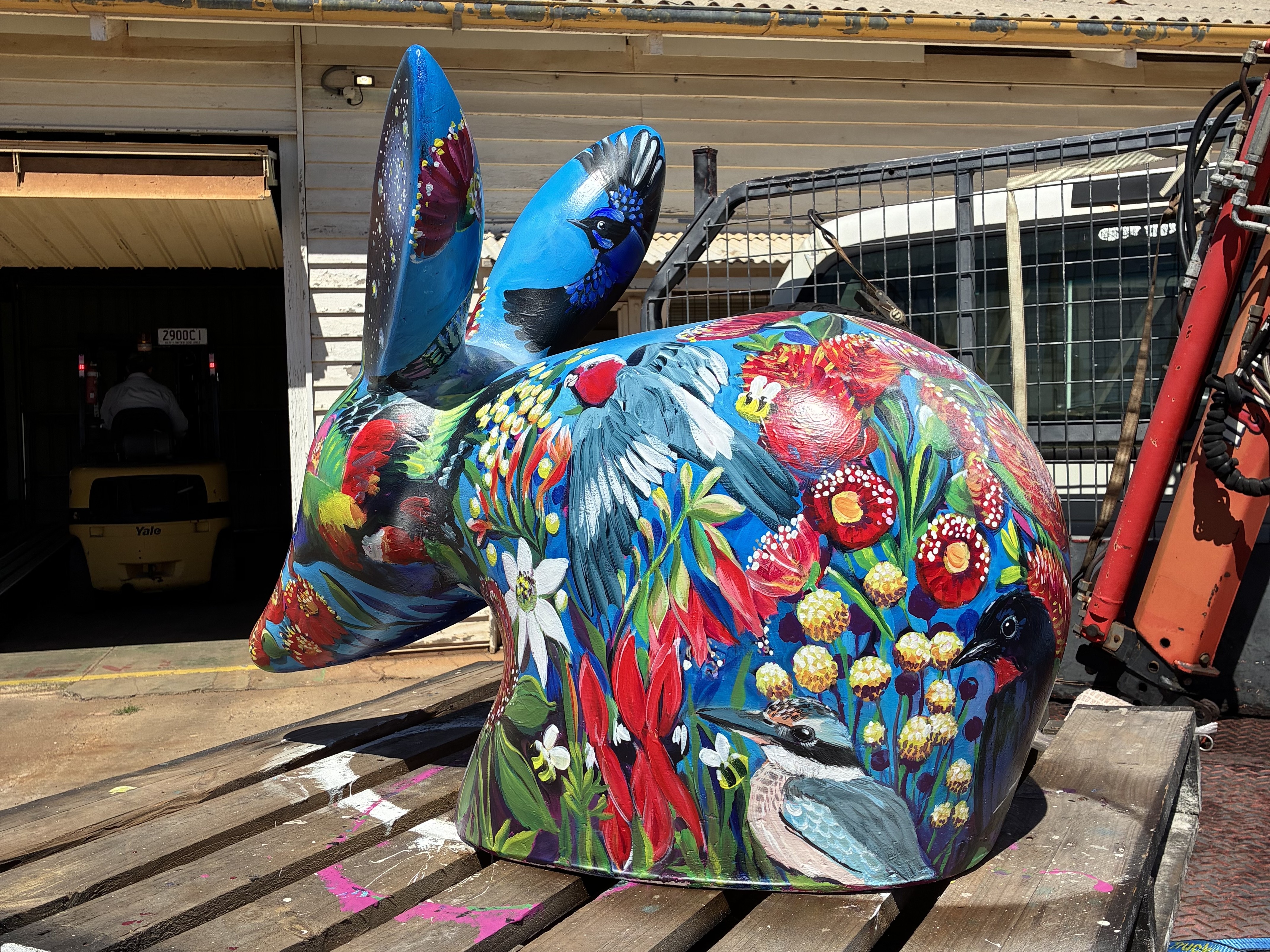 a bilby with a floral design sits on a pallet