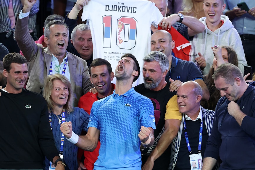 Novak Djokovic celebrates with his support team after winning the Australian Open men's singles title.