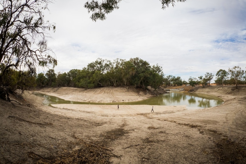A wide shot of people at a bend in the Darling River near Pooncarie's weir.