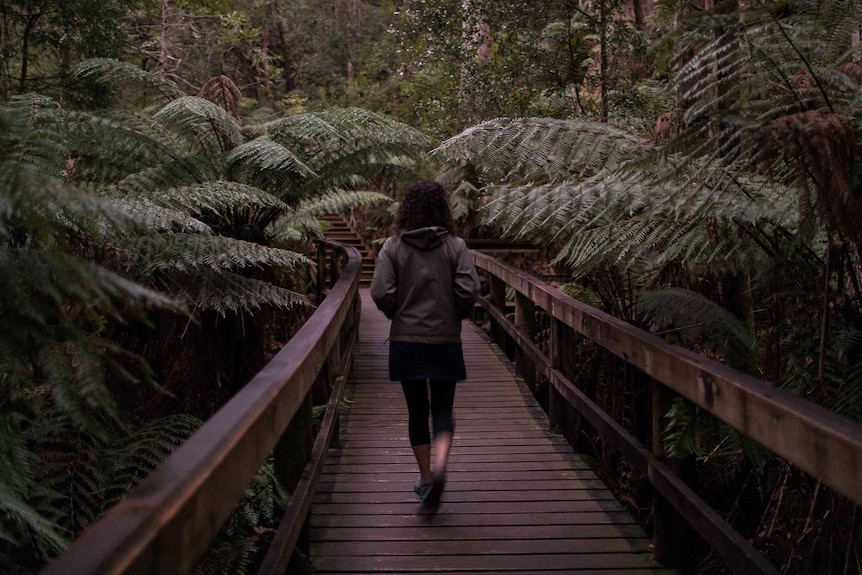 Woman walking in forest.