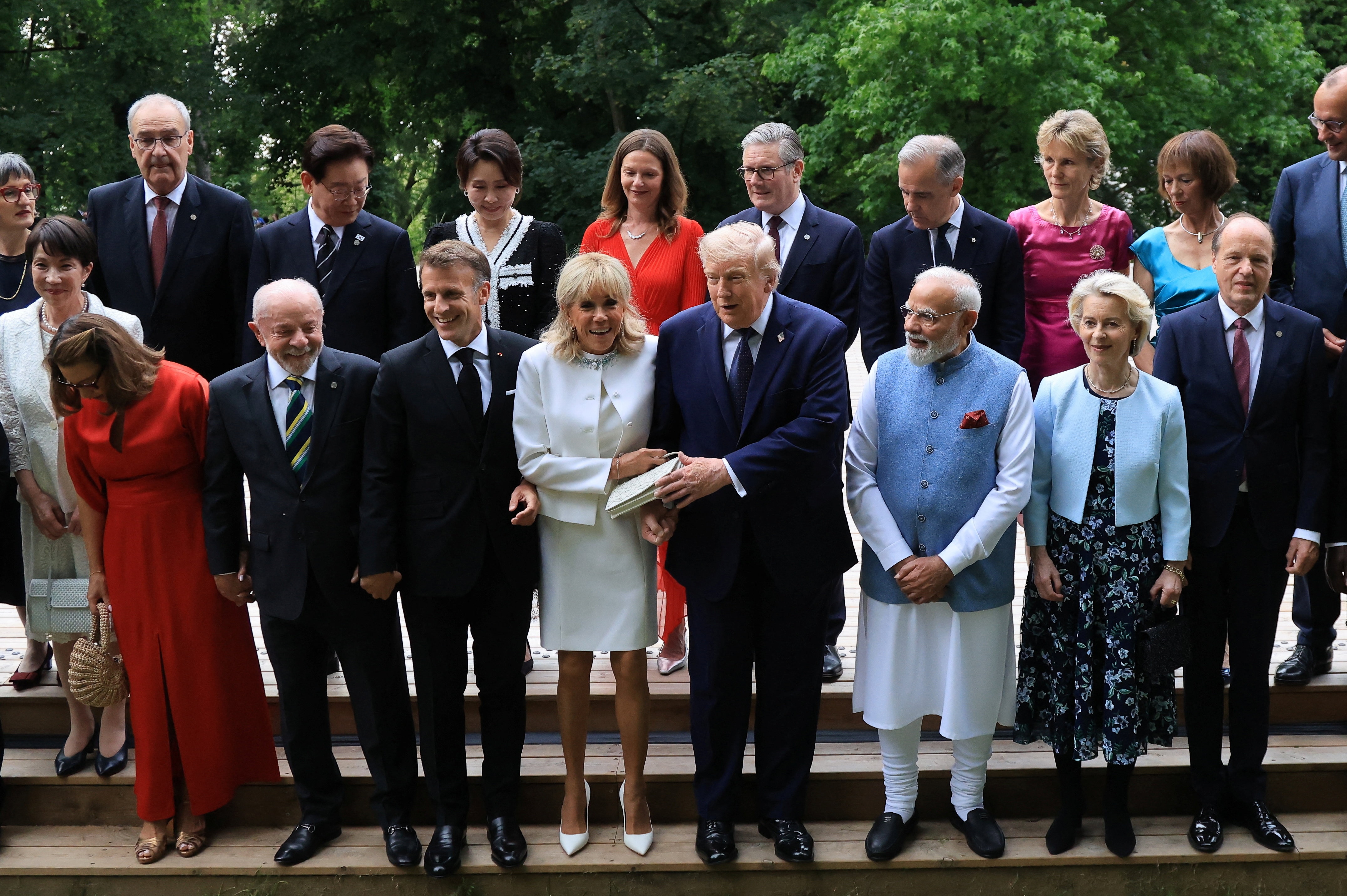 World leaders and their partners assemble for a 'family photo' on outdoor stairs.