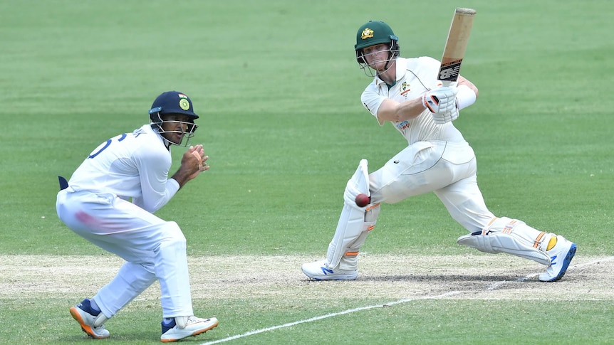 Australia batsman Steve Smith hits a cricket ball into Indian fielder Mayank Agarwal during a Test.