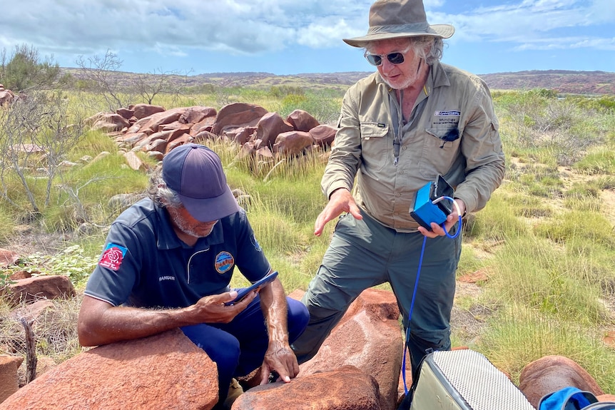 Two men using highly technical equipment to monitor rock art