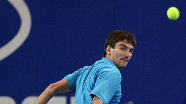 Tommy Robredo plays a backhand to John Isner en route to 6-7, 6-3, 7-6 win.