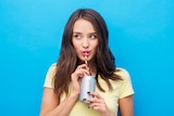 Young woman drinking soft drink from a can